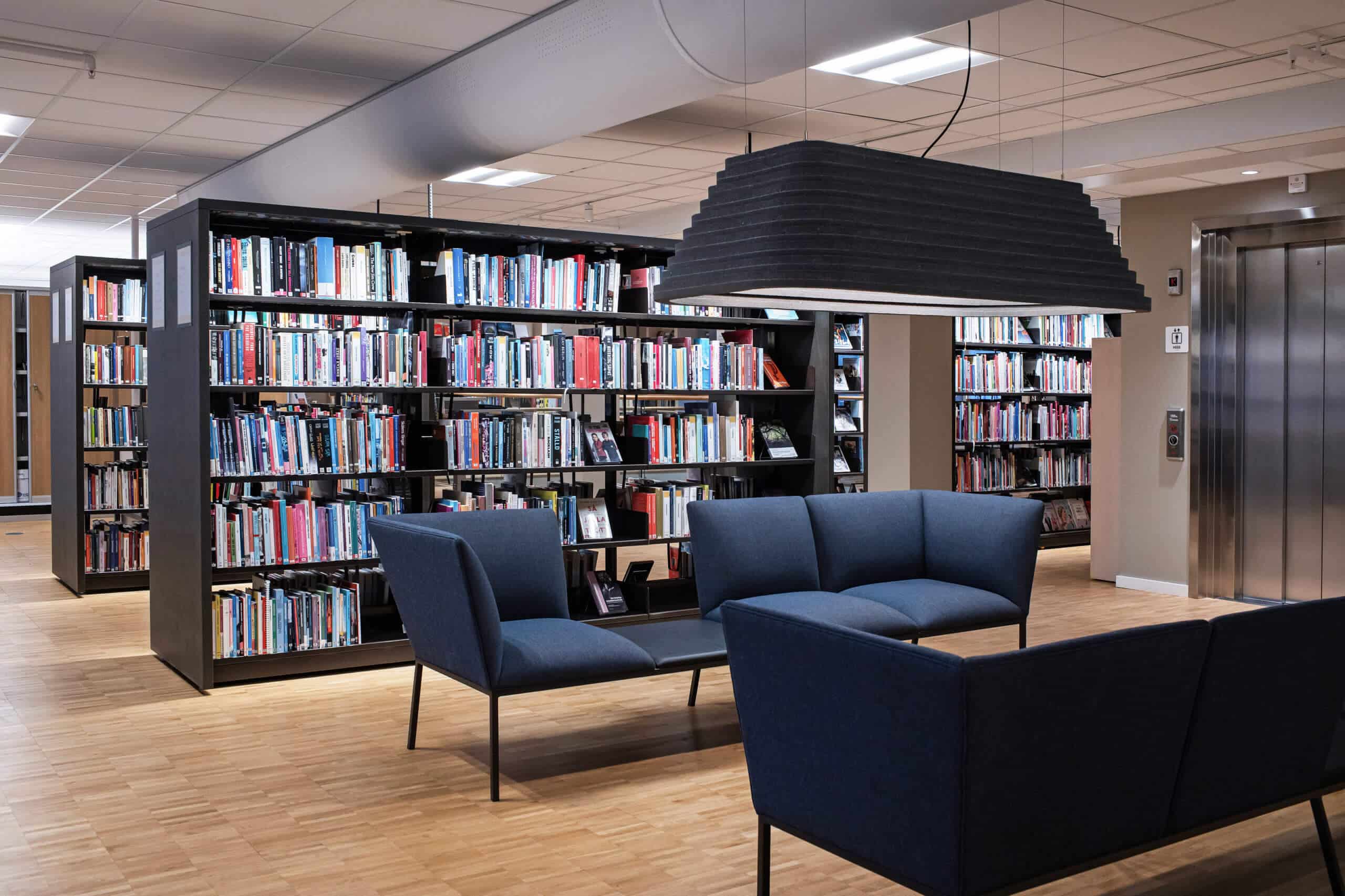 Två soffor bland hyllor av böcker